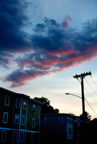 Dramatic pink and blue sunset clouds over urban apartment buildings