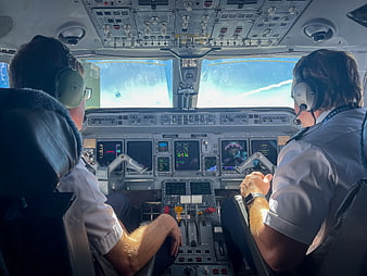 Two pilots flying a commercial airplane cockpit view