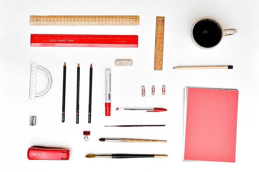 Flat Lay of Red Office Supplies and Stationery on White Background