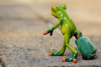 Cute green frog figurine pulling a miniature suitcase