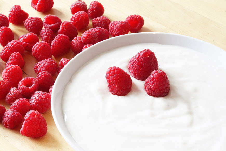 Fresh Raspberries and White Yogurt on Wooden Table