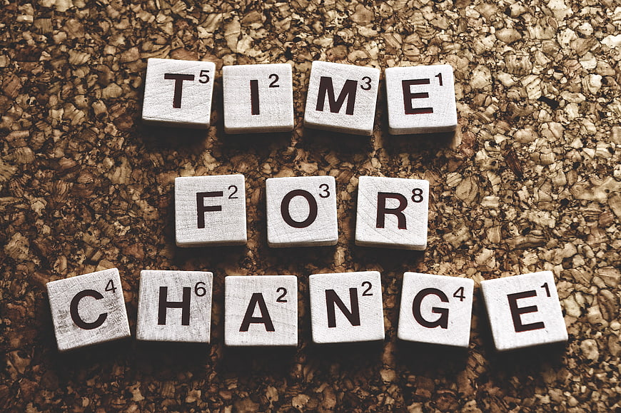 Scrabble tiles spelling Time For Change on cork background