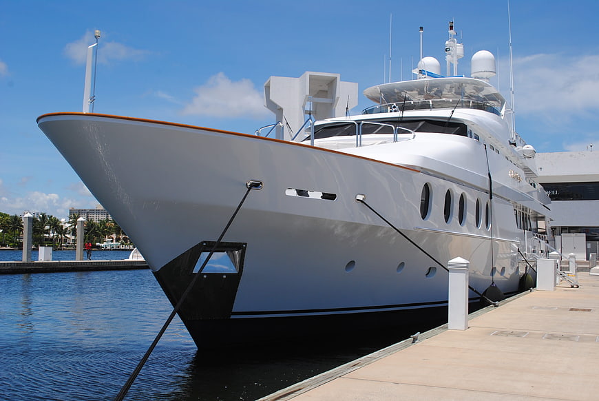 White luxury superyacht docked at marina on sunny day