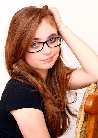 Portrait of young woman with red hair and glasses