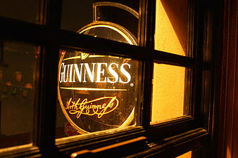Illuminated Guinness Pub Sign in Window at Night
