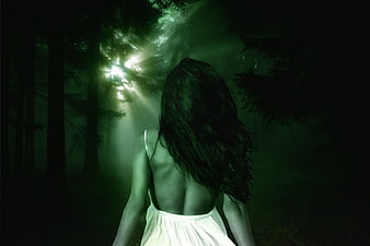 Mysterious Woman Walking Through Misty Forest With Dramatic Light Rays