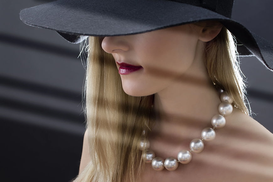 Elegant Woman in Black Hat with Pearl Necklace