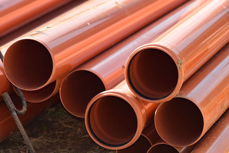 Stack of Orange Industrial Concrete Sewer Pipes