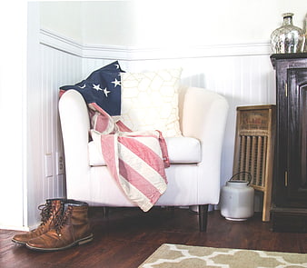 White armchair with American flag throw and brown boots