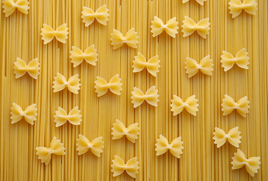 Top View of Farfalle Pasta on Spaghetti Background
