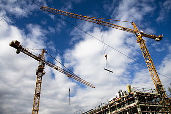 Yellow Construction Cranes Against Blue Sky