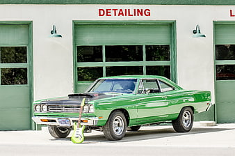 Classic Green Muscle Car with Guitar in Front of Garage