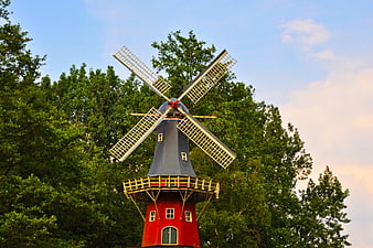 Traditional Red Dutch Windmill Against Blue Sky