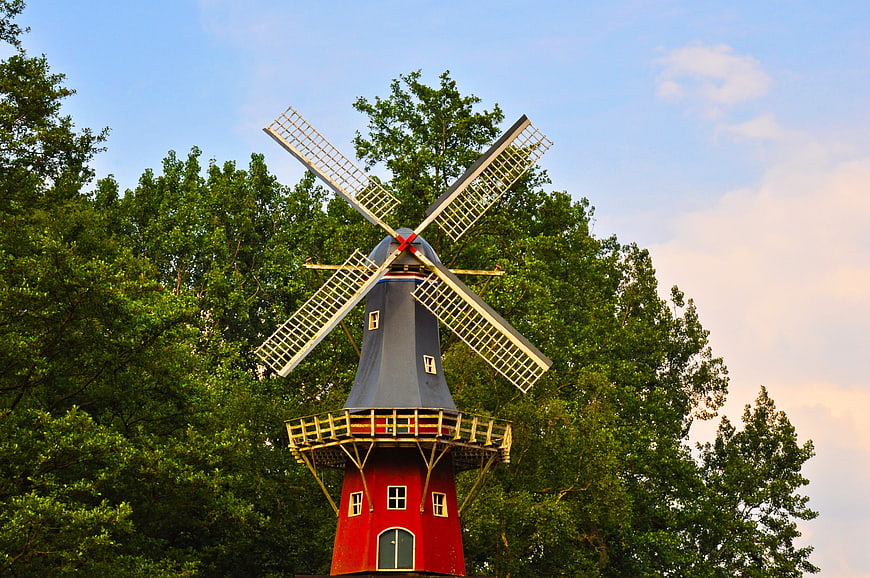 Traditional Red Dutch Windmill Against Blue Sky