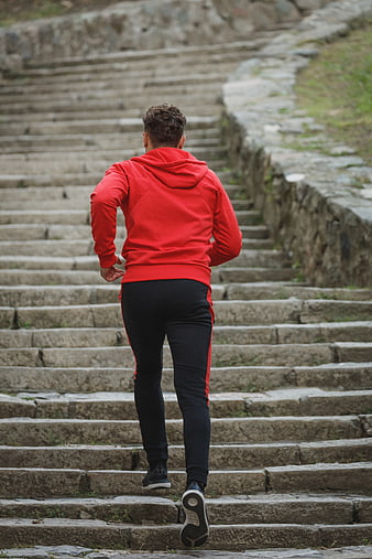 Man in Red Hoodie Running Up Stone Stairs