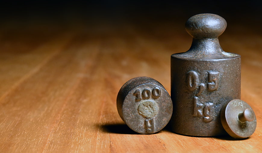 Vintage Cast Iron Weights On Wooden Surface