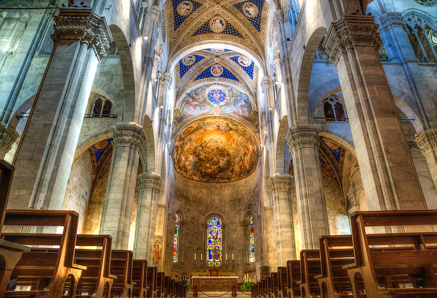 Interior of Lucca Cathedral with painted dome and stained glass