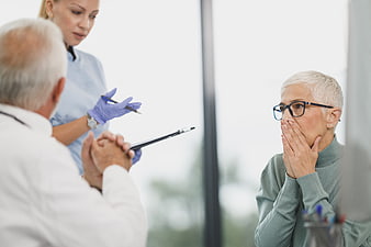 Senior woman reacting with shock to medical diagnosis