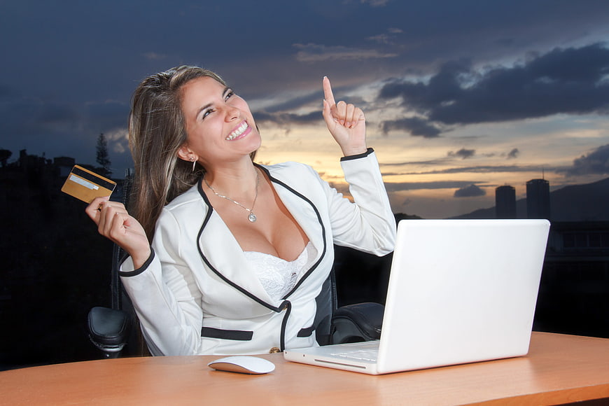 Smiling Business Woman with Credit Card and Laptop