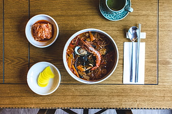 Top view of Korean spicy seafood soup with kimchi and pickled radish