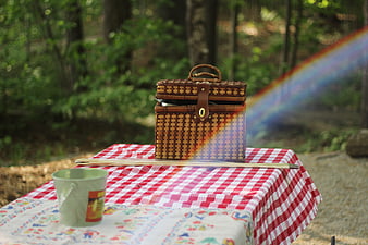 Wicker picnic basket on checkered tablecloth with rainbow