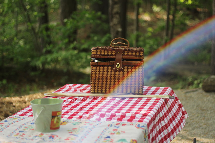 Wicker picnic basket on checkered tablecloth with rainbow
