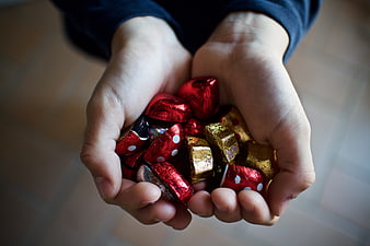 Child's Hands Holding Red and Gold Foil Wrapped Easter Chocolates