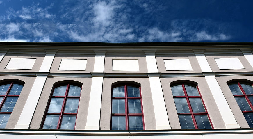Classical building facade with arched windows and blue sky