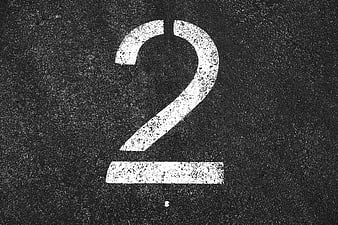 White Number Two Painted On Dark Asphalt Road Surface