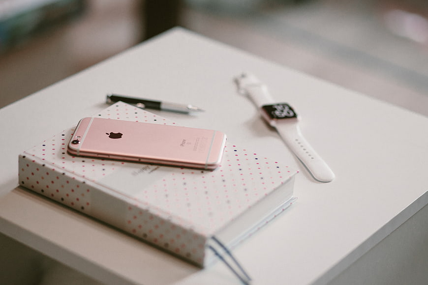 Rose Gold iPhone and Smartwatch on Polka Dot Notebook