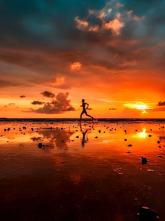 Silhouette of Man Running on Beach at Sunset