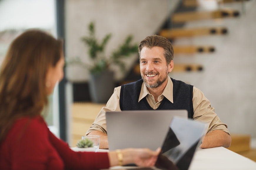 Smiling Businessman in Meeting with Female Colleague