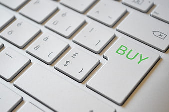 Close-up of a white laptop keyboard with a green BUY button