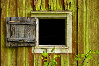 Rustic weathered wooden window with open shutter on old barn