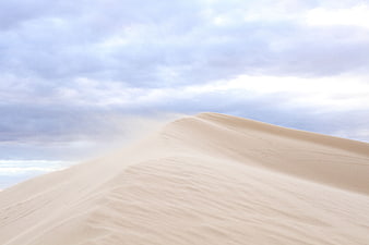 Sweeping Sand Dunes Under Cloudy Sky