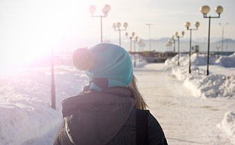 Woman in Blue Beanie Walking on Snowy Winter Path