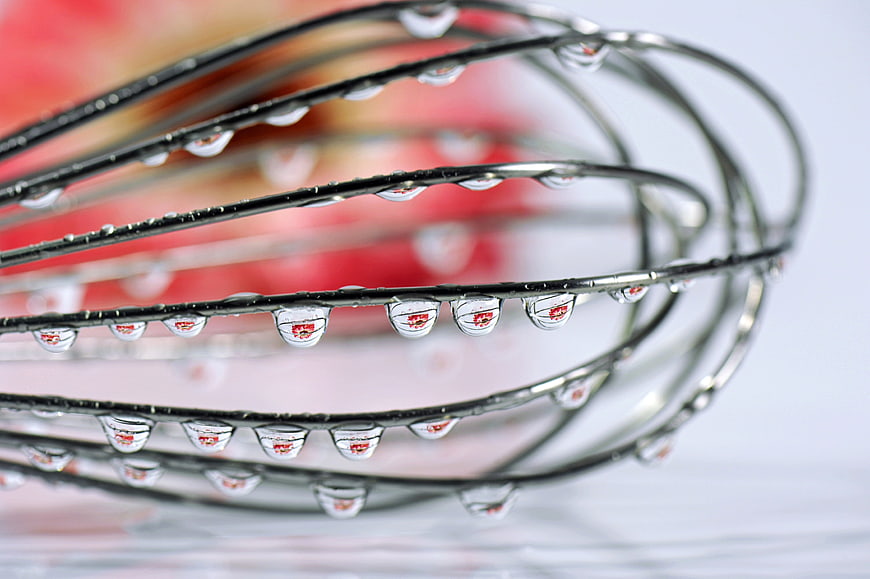 Macro shot of water droplets on metal whisk wires