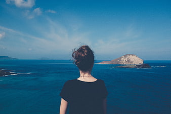 Woman looking at ocean view with distant island
