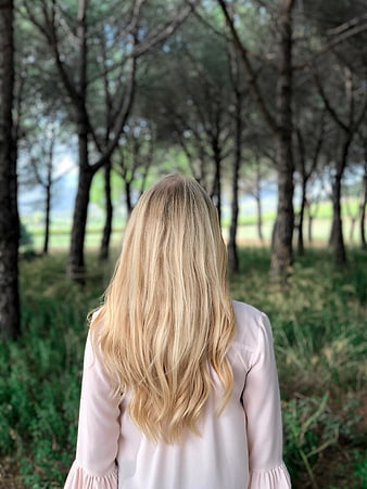 Blonde Woman Walking Away in Forest with Pink Blouse