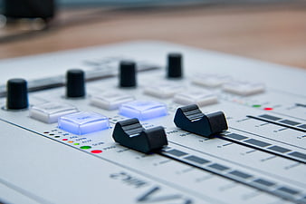Close-up of white audio mixer with glowing blue buttons