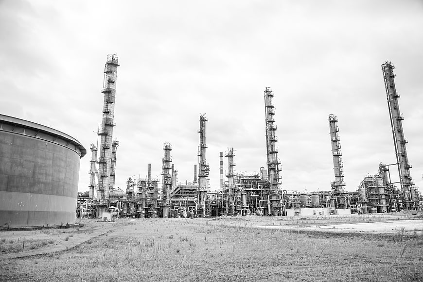 Black and white industrial refinery with tall towers