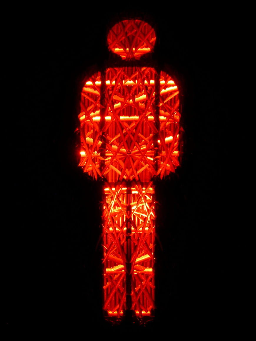 Red pedestrian traffic light symbol glowing on black background