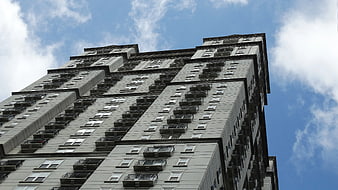 Low Angle View of Gray Apartment Building Against Blue Sky
