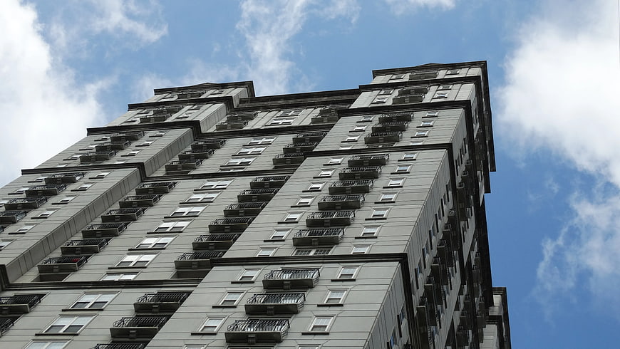 Low Angle View of Gray Apartment Building Against Blue Sky