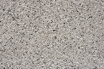 Close-up texture of gray concrete surface with black and white aggregate speckles