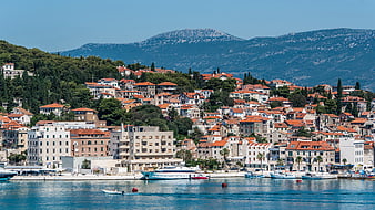 Coastal Town with Red Roofs and Mountains by the Sea