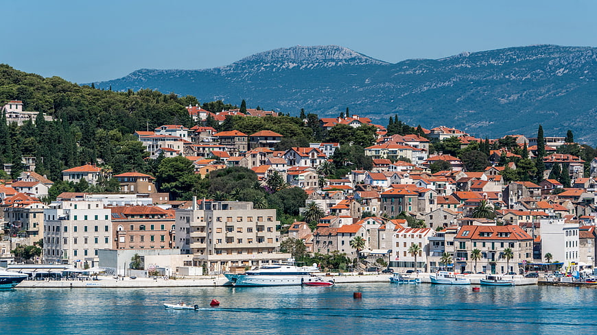 Coastal Town with Red Roofs and Mountains by the Sea