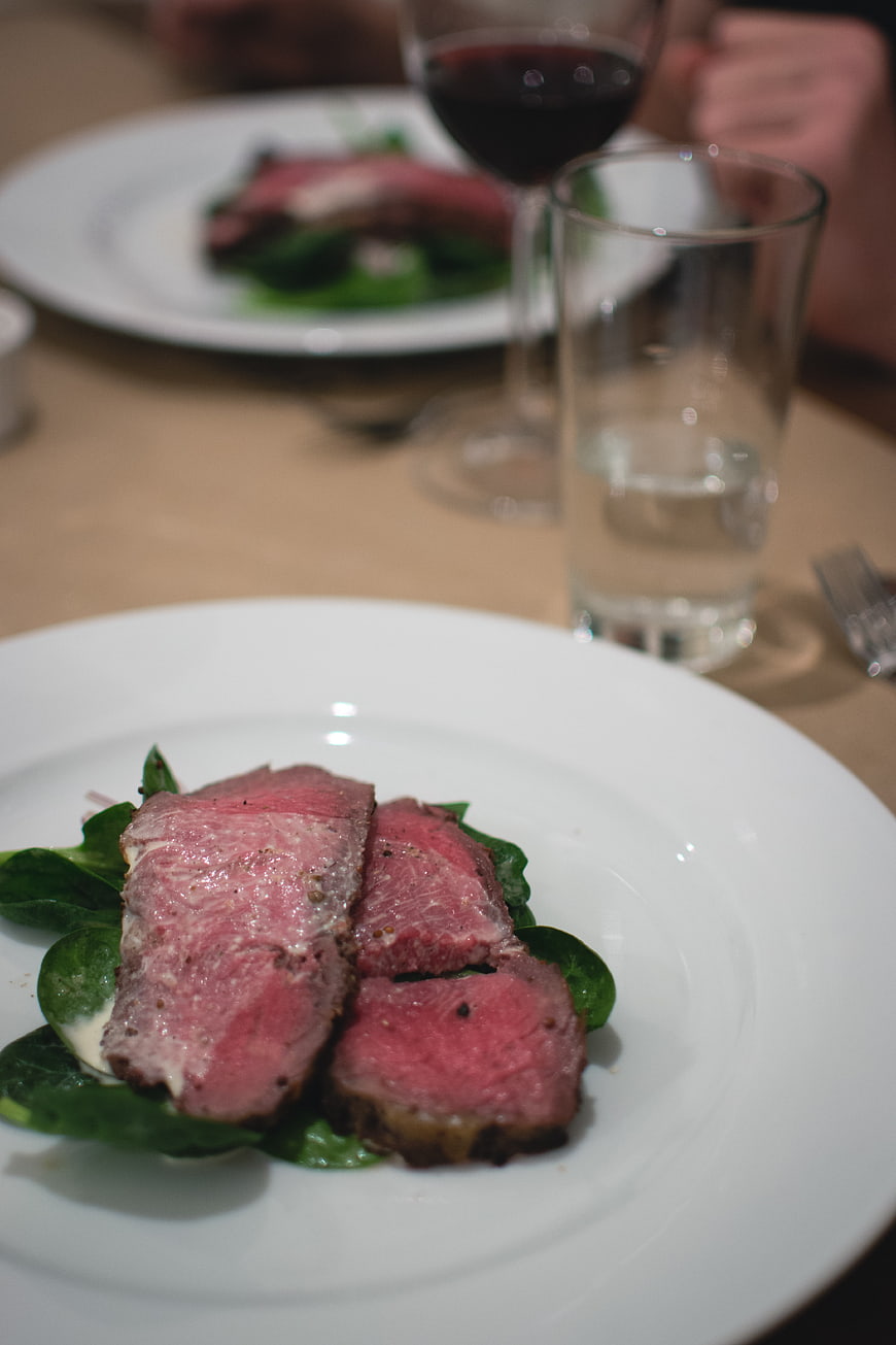 Sliced Rare Roast Beef on Spinach with Wine