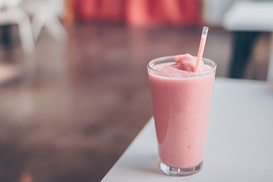 Pink Strawberry Smoothie in Glass with Straw
