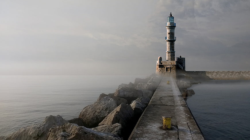 Misty Lighthouse on Stone Pier at Sea